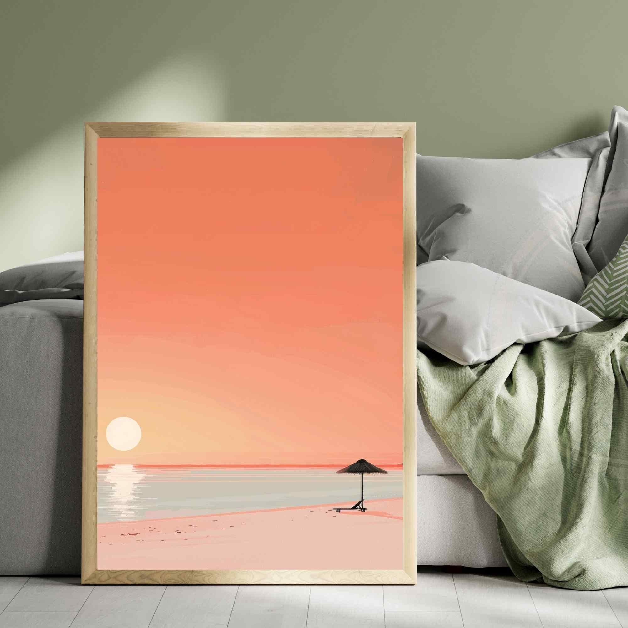 Framed artwork of a beach scene with a sunset over a body of water, placed on a sofa.